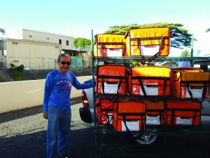 A Lanakila Meals on Wheels volunteer delivers food... and a smile.