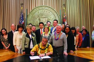 Gov. David Ige signs the Act into law at a ceremony with supporters.
