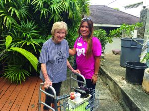 Photo of elderly woman being helped by of Hawaii Meals on Wheels