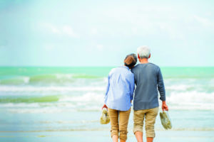 Relaxed senior couple on beach with blue sky background , Retirement travel holiday healthy lifestyle concept