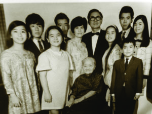 (L–R) Ginny poses with family members: Al, Liz (Morisada), Dany, Mom, Dad, Vicky (Cayetano), Joe, Ester (Schumacher) and Tony (in front of Joe). Grandma (seated) is from her paternal side. Her youngest brother, Donny, is not shown.