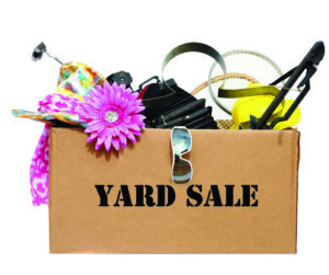 A large cardboard box filled with Yard Sale or Tag Sale items to be sold at a discount in order to make room and make some money at the same time. Yard Sales are an important part of our economy