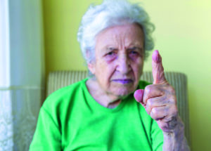 an angry old woman with her finger up for admonition /warning