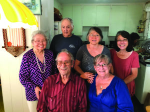 (L–R, front) George, Venetia, (back) Millie,Jr. Lee, Siri, Annette (background) and Ann
enjoy cards and camaraderie each week at
George’s house.
