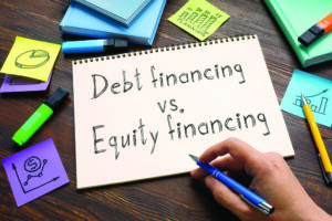 Debt financing vs. equity financing are shown on a photo using the text
