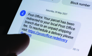 Genuine scam message seen on smartphone screen. Unpaid parcel shipping fees scam text. (Link is not active). Stafford, United Kingdom, June 7, 2021.