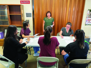 Judy Taketa, program director of CCH’s Case Management
Program for the Elderly, leads a discussion with
her team of case managers.